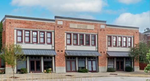 Chesterfield Mixed Use A close-up of the Dearborn Office Building within Chesterfield Mixed-Use, highlighting its symmetrical design with large second-floor windows and storefront-style entrances on the ground level. The metal awnings add a modern touch, while neatly trimmed shrubs frame the entrance.